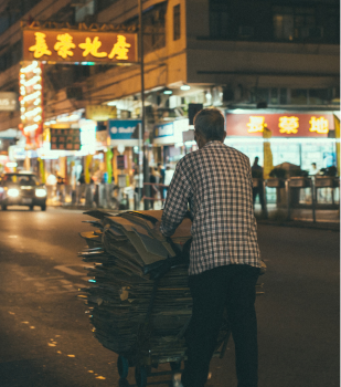 Homeless Man Pushing A Cart on Hong Kong Street At Night